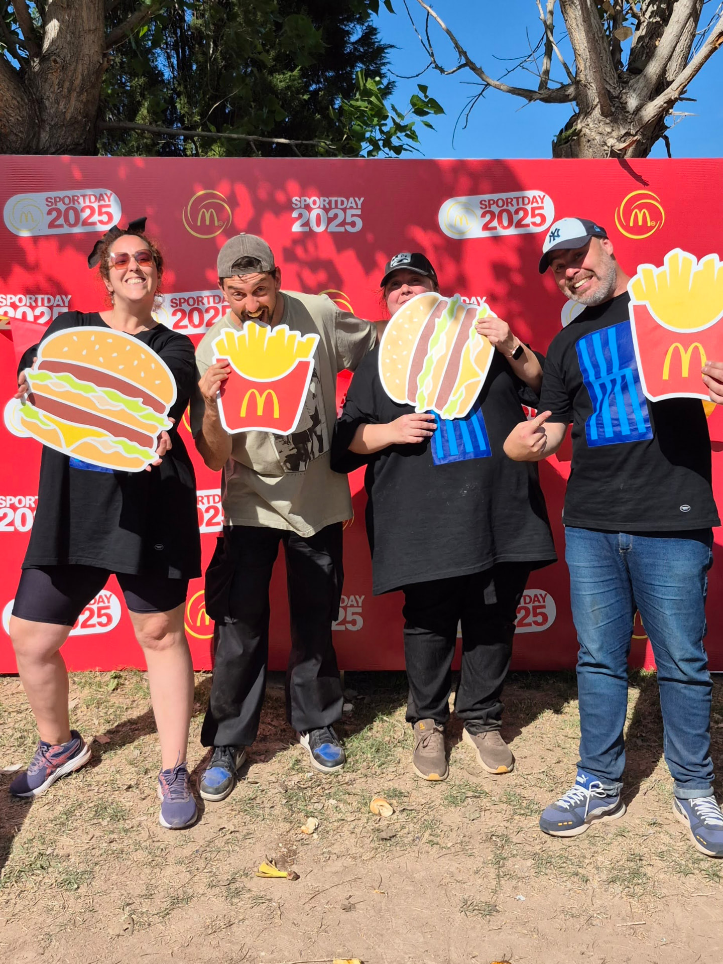 Equipo de McDonald's posando con recortes gigantes durante el Sport Day 2025